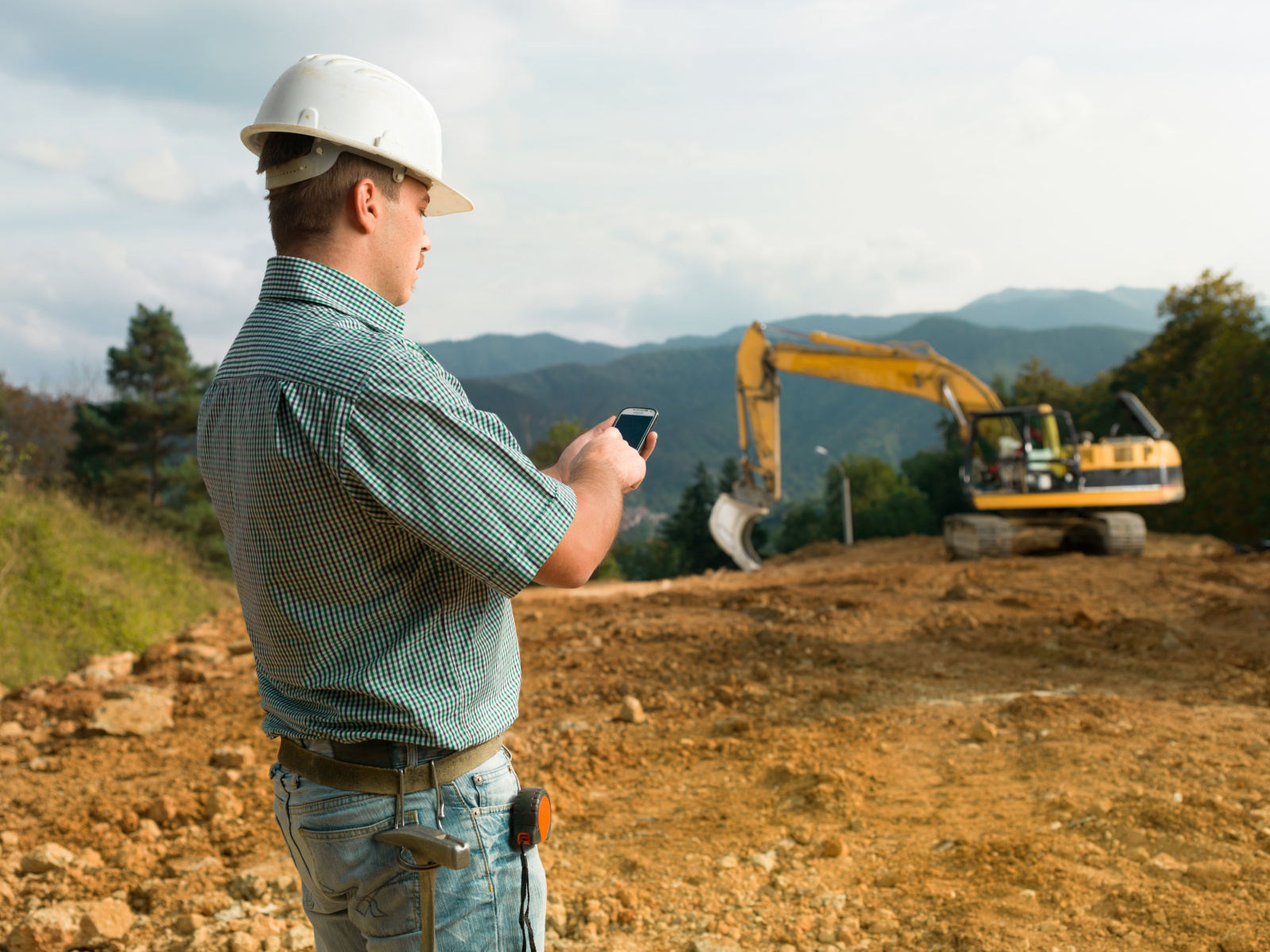 Construction worker with smart phone carrying out a site survey using the NestForms mobile survey app